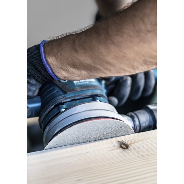 Detailaufnahme eines Exzenterschleifers in Gebrauch auf einem Holzbrett