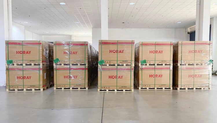 Mehrere Paletten mit Horay Solarmodul-Verpackungen, gestapelt im Lagerraum.