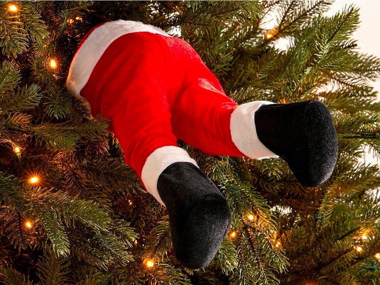 Weihnachtsbaumschmuck in Form von Beinen eines Weihnachtsmanns, die aus dem Tannenbaum ragen.