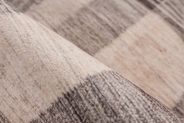 Detailansicht eines Teppichs mit gestreifter Textur und weichem Flor.