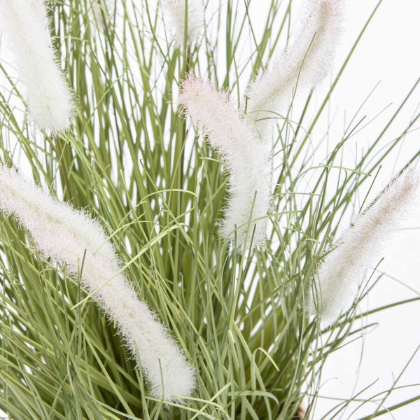 Künstliches Gras in einem Übertopf aus Jute.