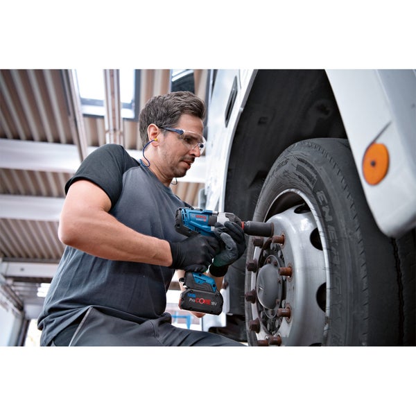 Ein Mann wechselt mit einem Akku-Schlagschrauber ein LKW-Rad.