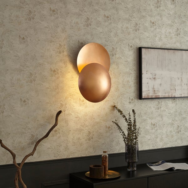 Wandleuchte mit zwei Kreisen an floral gemusterter Wand