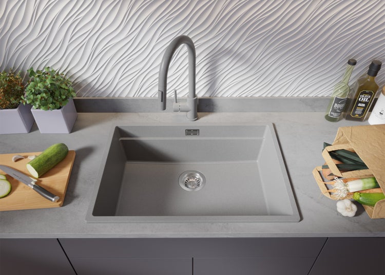 Spüle mit Armatur, Schneidebrett und Lebensmitteln in einer Küche