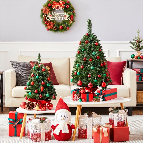 Weihnachtliche Wohnzimmerdekoration mit zwei Weihnachtsbäumen, Geschenken, Kranz und Schneemann