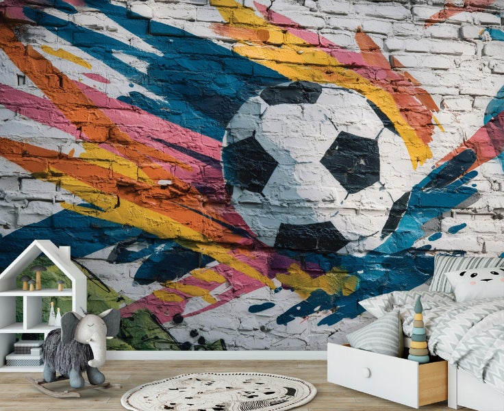 Fototapete mit Fußball-Graffiti auf einer Ziegelwand in einem hellen Kinderzimmer mit Kinderbett und Spielzeug.