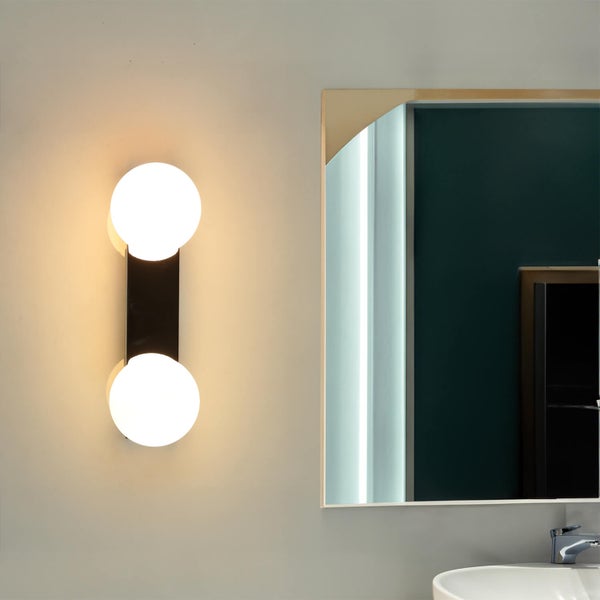 Badezimmer-Szene mit einer Wandleuchte mit zwei runden Glühbirnen und einem Spiegel
