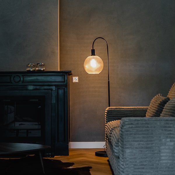 Wohnzimmer mit Kamin, Stehlampe und Sofa