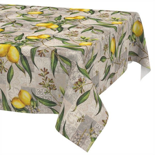 Tischdecke mit Zitronen- und Blättermotiv auf einem Hintergrund in Patchwork-Optik.