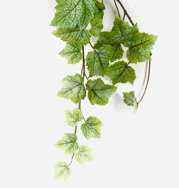 Künstliche Hängepflanze mit grünen, strukturierten Blättern.