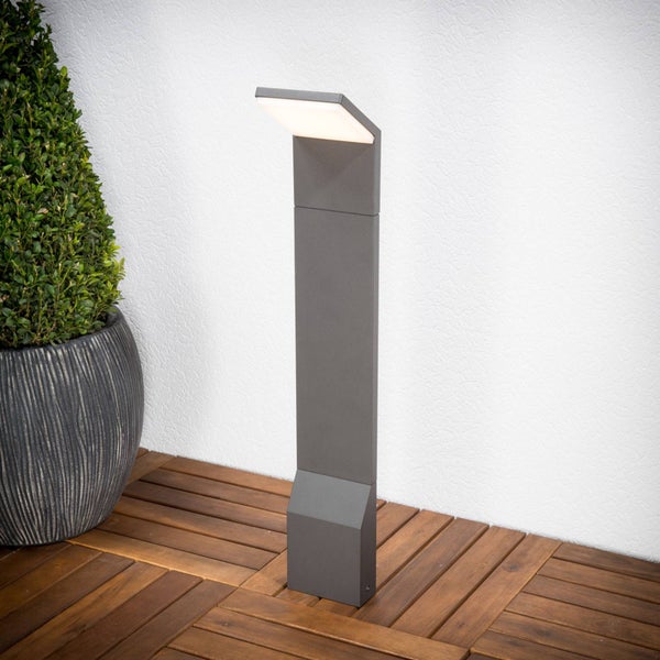 Anthrazitfarbene LED-Sockelleuchte für den Außenbereich auf einem Holzdeck neben einem Pflanzgefäß.