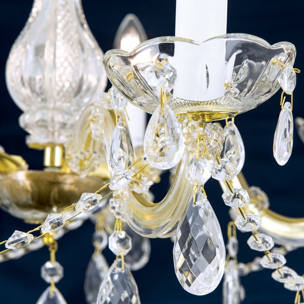 Detailansicht eines Kronleuchters mit Glasbehang und Kerzenoptik Elementen in Gold und Glas