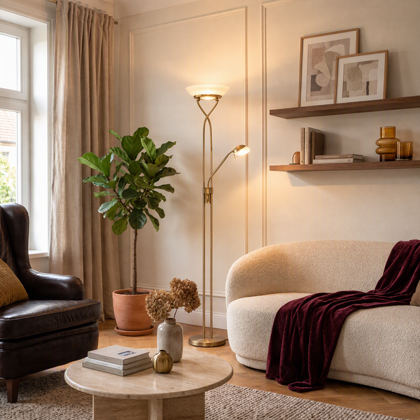 Wohnzimmer mit Deckenfluter und Leselampe in Messing, helles Sofa mit Überwurf, Ledersessel, Couchtisch und Pflanze im natürlichen Einrichtungsstil