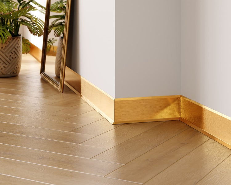 Eckansicht eines Raumes mit goldfarbenen Sockelleisten an der Wand