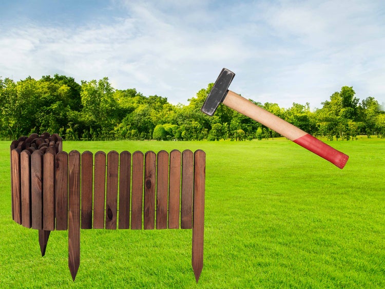 Gartenszene mit Holzzaun und Hammer auf einer Wiese