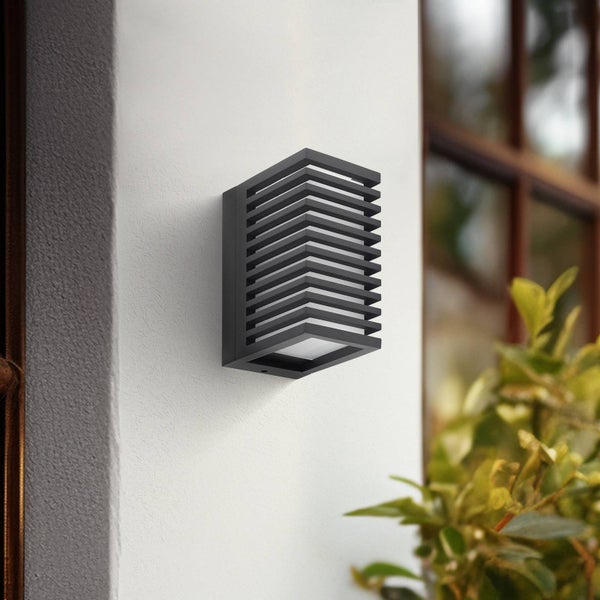 Moderne rechteckige Außenwandleuchte mit horizontalen Lamellen, an einer weißen Hauswand montiert.