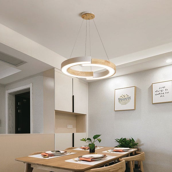 Runde LED-Hängeleuchte aus Holz und Metall über einem Esstisch