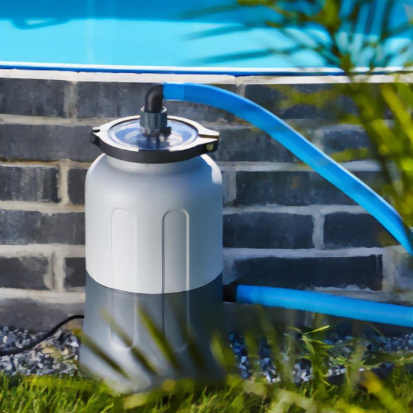 Sandfilteranlage für den Pool mit blauen Schläuchen vor Steinwand