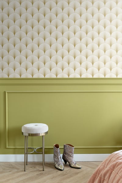 Wohnraum mit gemusterter Tapete, Wandpaneelen, Hocker und Stiefeln