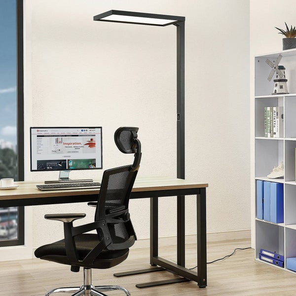 Moderner Arbeitsplatz mit schwarzer LED Bürostehleuchte über einem Schreibtisch mit Computer, ergonomischem Netzstuhl und weißem Regal.