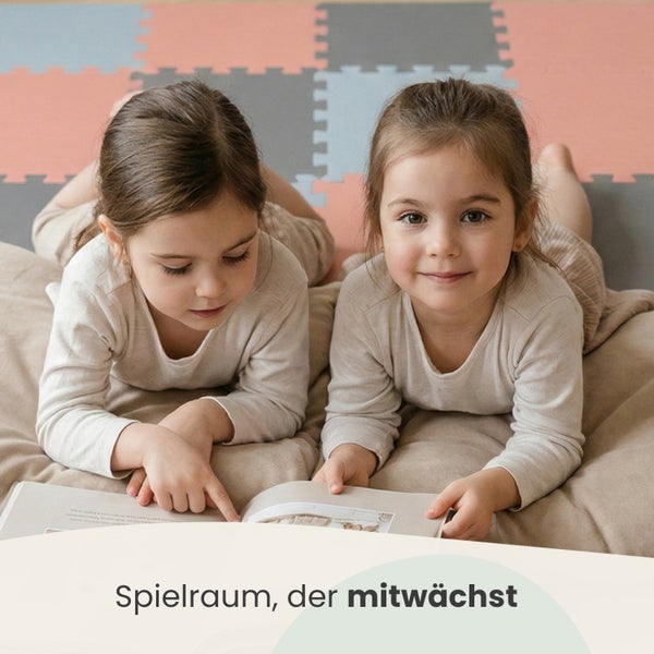 Zwei Kinder lesen ein Buch in einem hellen Spielzimmer auf einem Sitzsack. Im Hintergrund liegt eine Puzzlematte auf dem Boden.