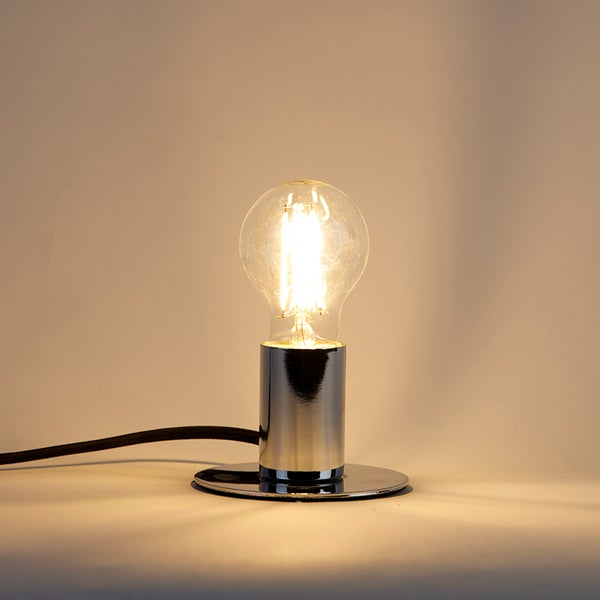 Kleine minimalistische Tischlampe aus verchromtem Metall mit leuchtendem LED-Filament-Leuchtmittel und schwarzem Textilkabel.