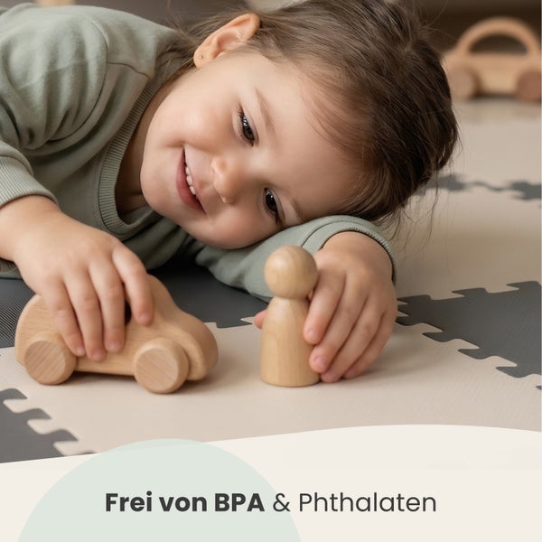 Kind spielt mit Holzspielzeug auf einer Puzzlematte, die frei von Bisphenol A und Phthalaten ist.