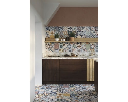 Küchenszene mit Mosaikfliesen an Boden und Wand, sowie einem dunklen Unterschrank und einer Ablagefläche