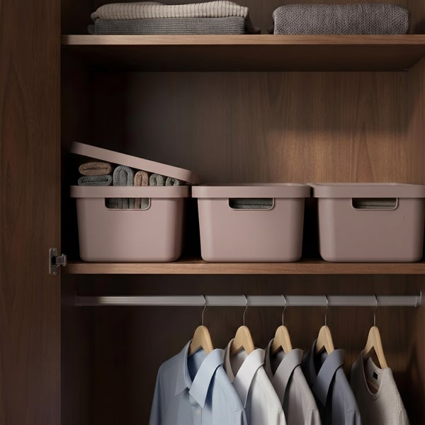 Organisierter Kleiderschrank aus Holz mit Aufbewahrungsboxen und hängenden Hemden auf Kleiderbügeln.