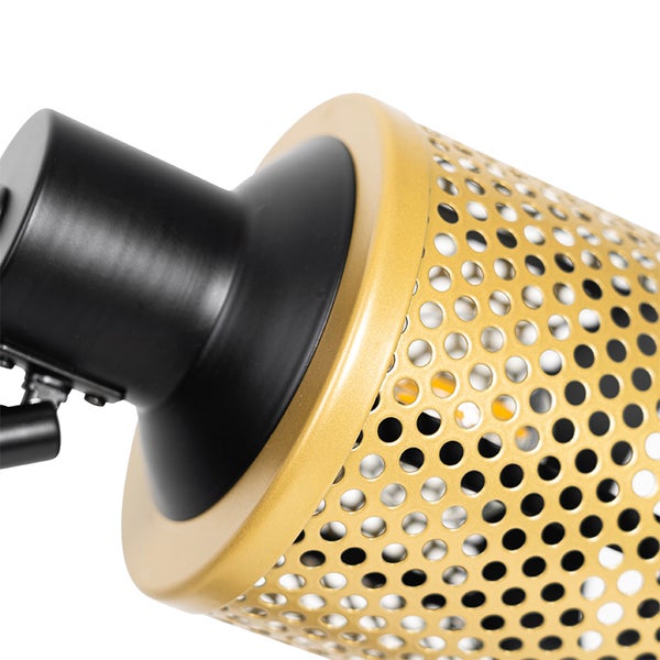 Detailaufnahme einer Lampe mit goldenem, perforiertem Lampenschirm und schwarzer Halterung.