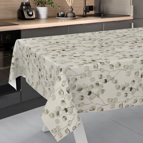 Tischdecke mit Eukalyptus-Blättermuster auf einem Tisch in einer modernen Küche mit dunklen Fronten und heller Arbeitsplatte.