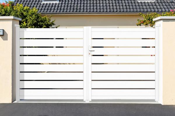 Doppelflügeltor mit horizontalen Lamellen vor einem Haus
