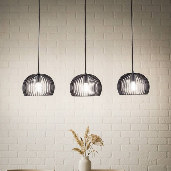 Drei Pendelleuchten aus Metall über einem Tisch