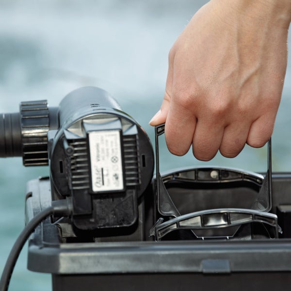 Hand greift den Reinigungsgriff eines Oase Teichfilters zum Anheben der Filterschwämme.