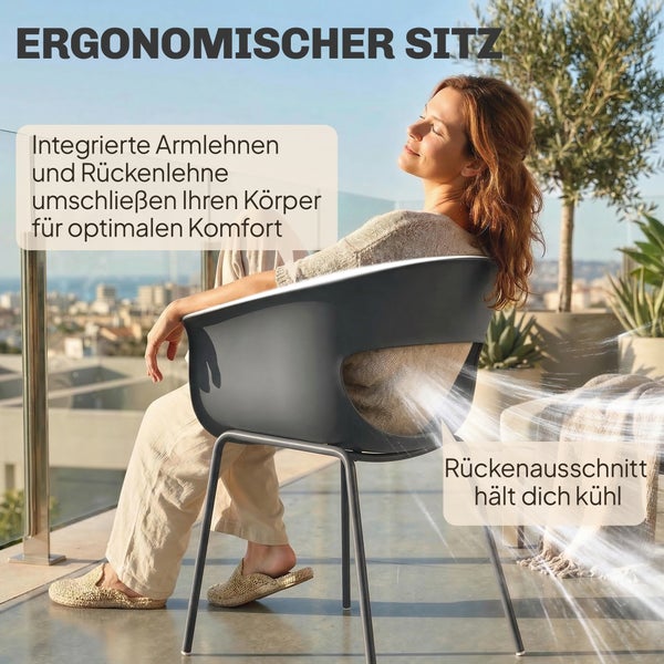 Person sitzt auf einem ergonomischen Outdoorstuhl mit Armlehnen und Rückenausschnitt auf einer Terrasse mit Stadtblick.