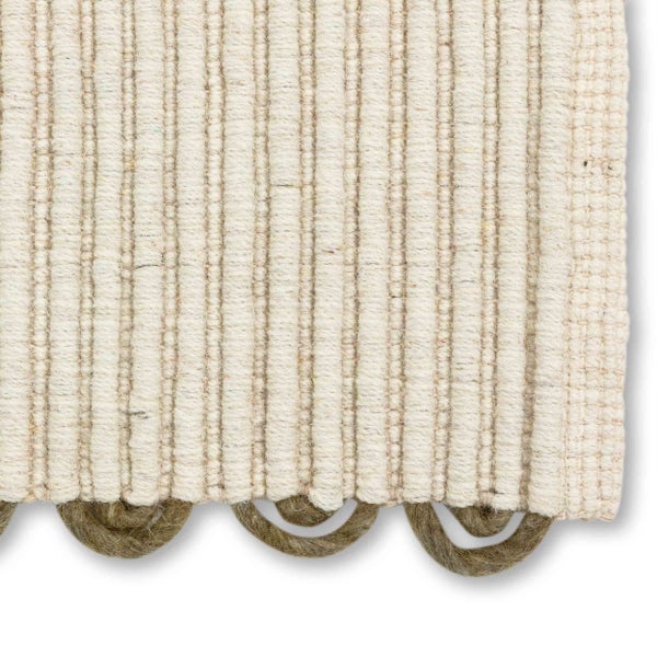 Gewebter Teppich in Beige mit Rippenstruktur und dekorativem braunem Schlaufenrand aus Naturfasern.