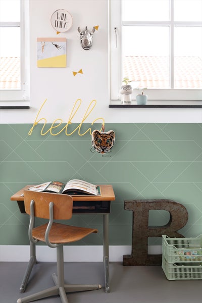Kinderzimmer mit Schreibtisch, Stuhl, geometrischer Tapete und dekorativen Elementen