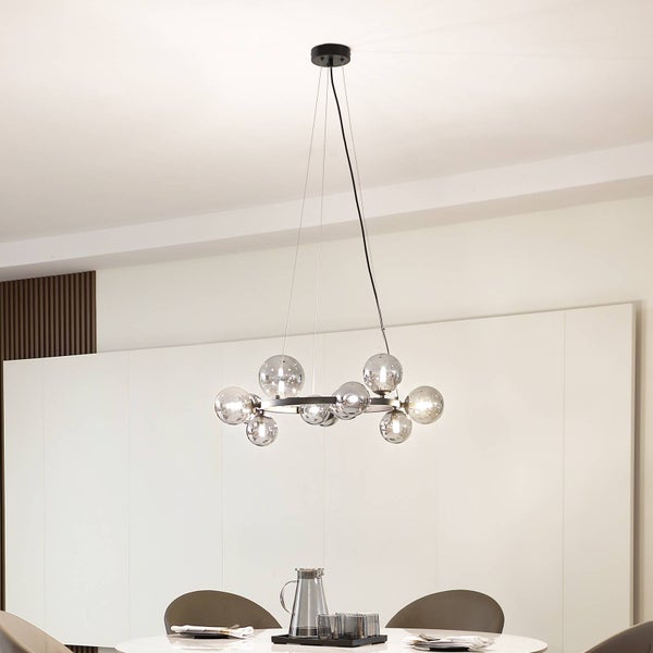 Moderne Hängeleuchte mit kreisförmigem Design und mehreren Glaskugeln über einem Esstisch.