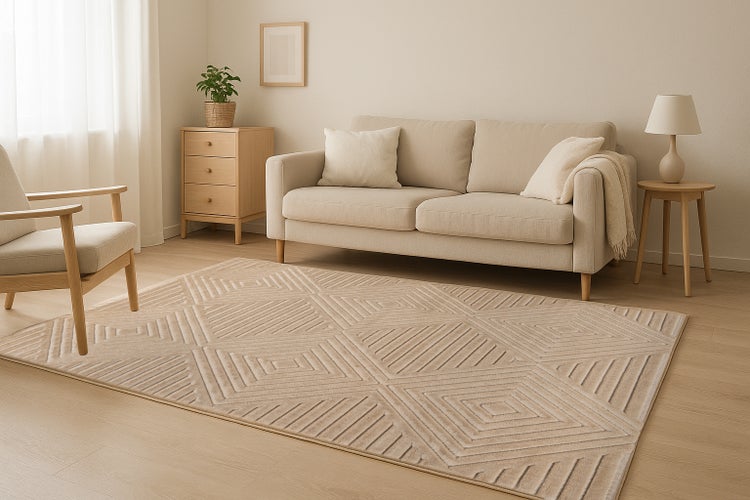 Wohnzimmer mit Sofa, Sessel und rechteckigem Teppich mit geometrischem Rautenmuster in einem modernen und hellen Einrichtungsstil.
