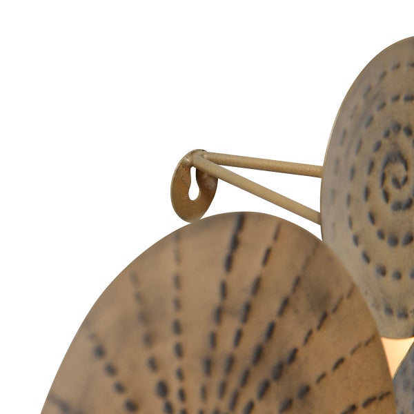 Detailansicht einer Wanddekoration aus Metall mit kreisförmigen Elementen und Befestigung.