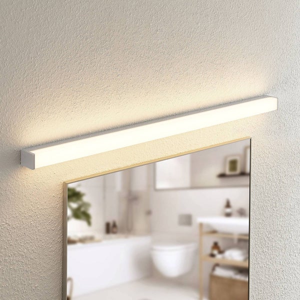 Moderne LED Badezimmerspiegelleuchte in Silber, oberhalb eines Spiegels an einer strukturierten Wand montiert, für helle Ausleuchtung.