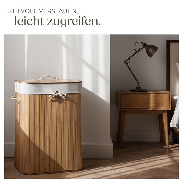 Wäschekorb aus Bambus mit Stoffeinsatz und Deckel in einem modern eingerichteten Schlafzimmer mit Nachttisch und Lampe.