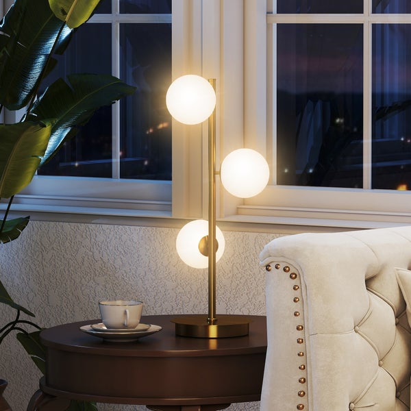 Dekorative Tischleuchte mit drei Leuchtkugeln auf einem Beistelltisch