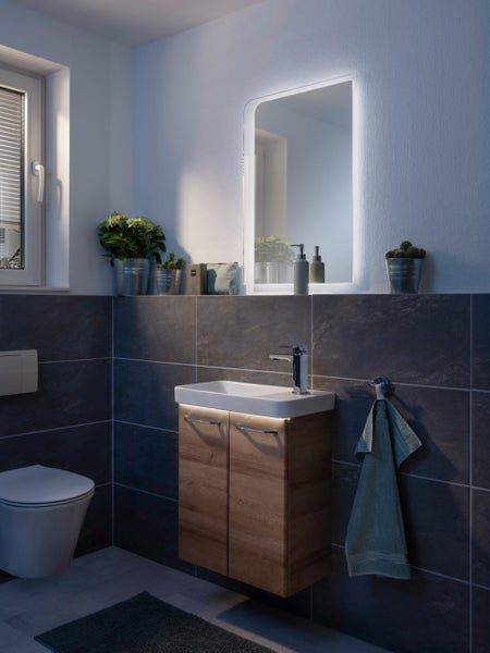 Modernes Badezimmer mit Waschtischunterschrank, Spiegel und Toilette.