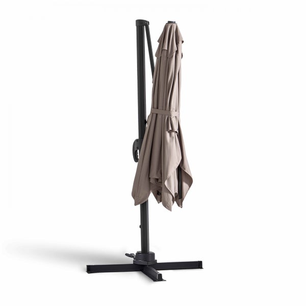 Geschlossener Ampelschirm mit taupefarbenem Bezug und schwarzem Metallgestell auf einem Kreuzfuß.