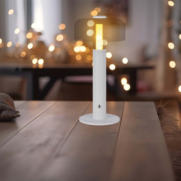 Weiße Tischleuchte mit gelbem Licht auf einem Holztisch
