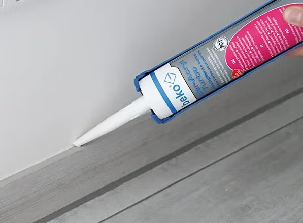 Anwendung von Beko Maleracryl Turbo Dichtstoff mit einer Kartuschenpresse an einer Fußleiste.
