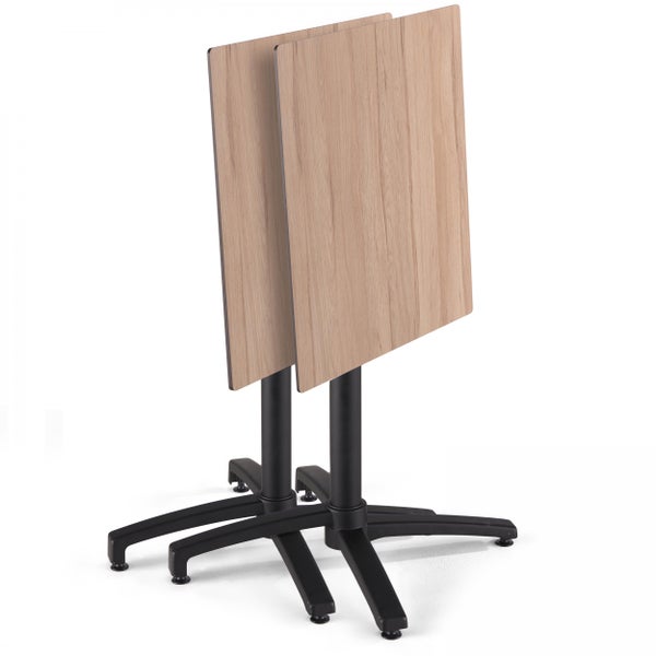 Zwei klappbare Bistrotische mit quadratischer Tischplatte in Holzoptik und schwarzem Metallfuß, platzsparend zusammengeklappt.