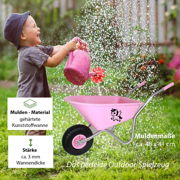 Kinder-Schubkarre aus rosa gehärtetem Kunststoff mit Einhorn-Motiv und Metallgestell, circa 48 mal 41 Zentimeter, im Garten mit spielendem Kind.