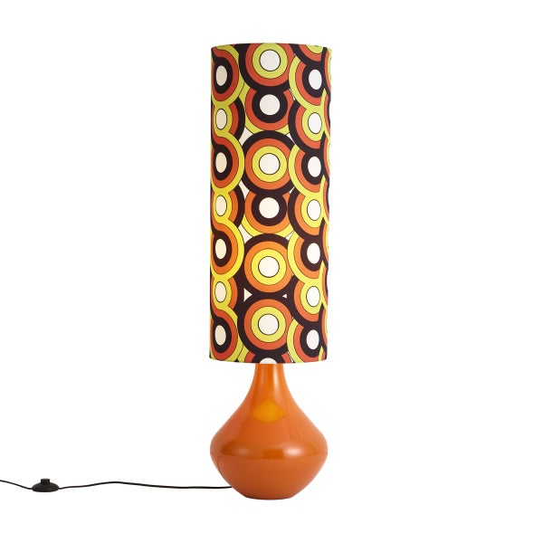 Retro-Tischleuchte mit zylinderförmigem Stoffschirm mit buntem Kreismuster im 70er-Jahre-Stil und orangefarbenem Keramikfuß.